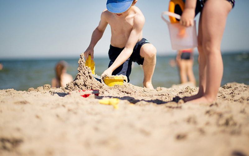 Kinder spielen am Sandstrand im Urlaub